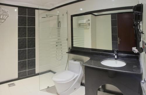 a bathroom with a toilet and a sink at Mina Concorde Hotel in Makkah
