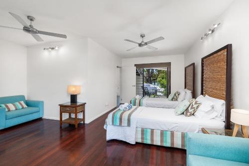 1 dormitorio con 2 camas y sofá azul en Onda Beach Clifton Beach en Clifton Beach