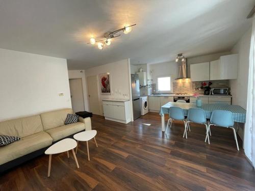 un salon avec un canapé, une table et des chaises dans l'établissement Spacieux T3 PMR près de la plage avec terrasse, Wifi et parking à Capbreton - FR-1-413-214, à Capbreton