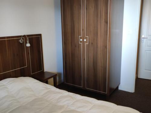 1 dormitorio con armario de madera junto a la cama en Appartement Jausiers, 3 pièces, 6 personnes - FR-1-165B-52 en Jausiers