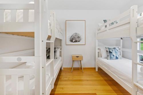 een slaapkamer met witte stapelbedden en een bureau bij Sun Valley - Boutique Portsea Accommodation in Portsea