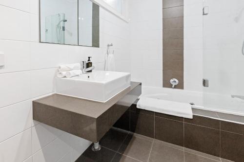 a white bathroom with a sink and a bath tub at Sun Valley - Boutique Portsea Accommodation in Portsea