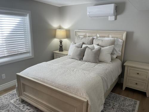 um quarto com uma cama grande com lençóis brancos e almofadas em Santaquin Canyon Mid-Term Rental--Your home away from home! em Payson