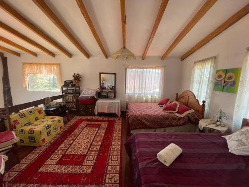 una habitación con 2 camas y una habitación con 2 mesas en Cabaña privada en Samaipata Getsemani JLO, en Samaipata