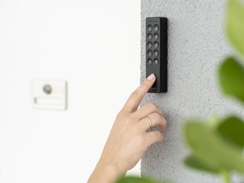 a person pressing a remote control on a wall at Ferienwohnung Radebeul Self Check-in in Radebeul