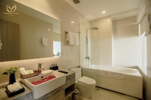 a bathroom with a sink and a tub and a toilet at Hon Chong Retreat Hotel in Nha Trang