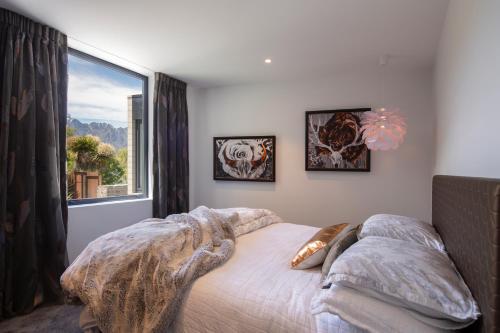 a bedroom with a bed and a large window at Ivy Box Art Gallery Apartment in Queenstown