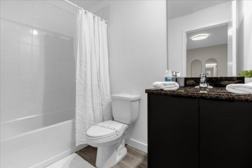 a white bathroom with a toilet and a shower at 3 Bedrooms- 3 Bathrooms The Hub 3361 Tt in Orlando