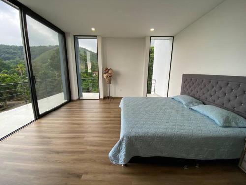 1 dormitorio con 1 cama grande y ventanas grandes en Moderna, tranquila y recreativa, en Ibagué