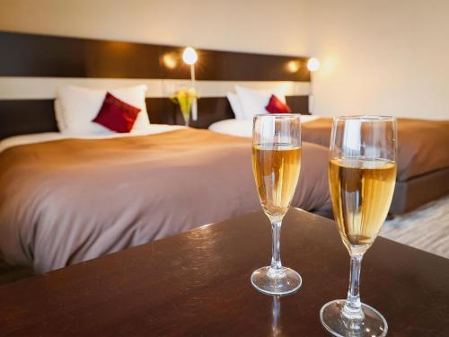 two glasses of champagne sitting on a table in a hotel room at Fukui Hotel in Obihiro