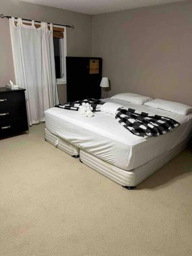 a bedroom with a large bed with black and white sheets at Sweet home in Ottawa