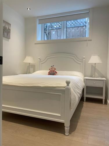 a teddy bear sitting on a bed in a bedroom at Brand new 1Queenbed family suite near UBC in Vancouver