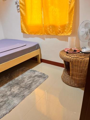 a bedroom with a bed and a table and a rug at La casa d aitor in Puerto Princesa City