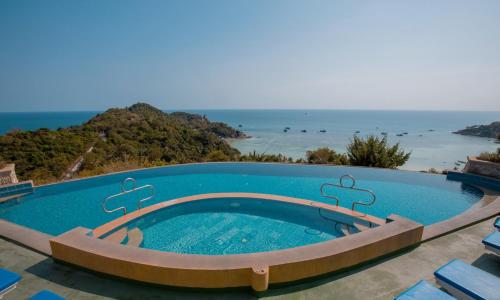 a swimming pool with the ocean in the background at Ko Tao Paradise Resort in Ko Tao