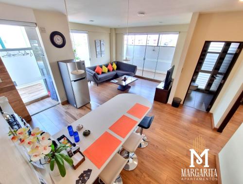 a view of a living room with a table and a couch at Margarita Apartamentos in Cochabamba