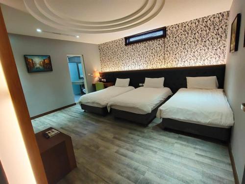 a hotel room with two beds and a wall at 晶緻麗景-花蓮火車站正對面 附近有大型收費停車場 in Hualien City