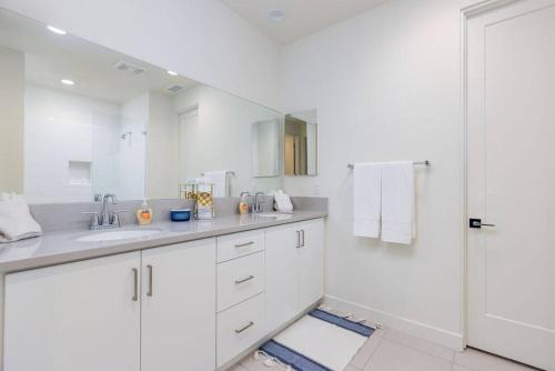 a white bathroom with a sink and a shower at Near Coachella and Stagecoach Palm Springs , PGA resort Villa ,Golf, community pool, gym in La Quinta