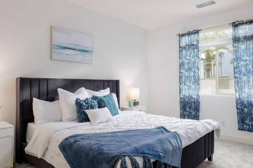a bedroom with a large bed with blue and white pillows at Near Coachella and Stagecoach Palm Springs , PGA resort Villa ,Golf, community pool, gym in La Quinta