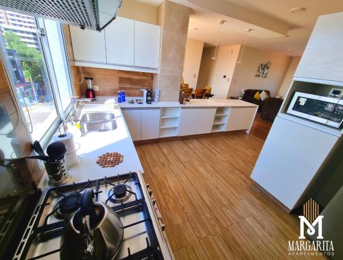 a kitchen with white cabinets and a stove top oven at Margarita Apartamentos in Cochabamba
