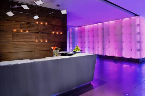 a lobby with purple lighting and a reception counter at W Dallas - Victory in Dallas