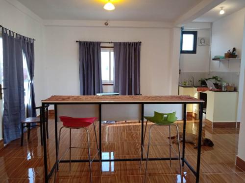 a kitchen with a table and two stools at KOL House in Phnom Penh