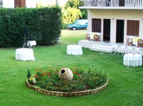 a yard with two tables and a plant in the grass at Avaton Hotel in Ligourio