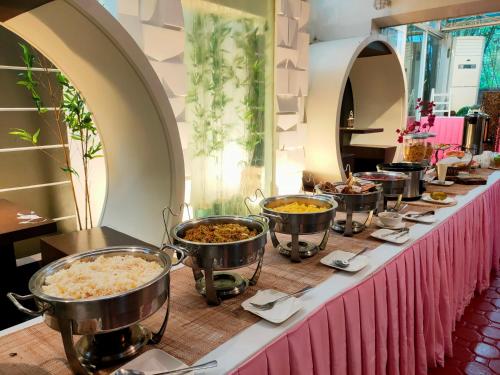 a buffet line with bowls of food on a table at Emerald Boutique Hotel in Legazpi