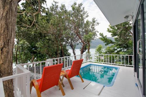 un balcón con 2 sillas y una piscina en Casa De Lipe en Ko Lipe