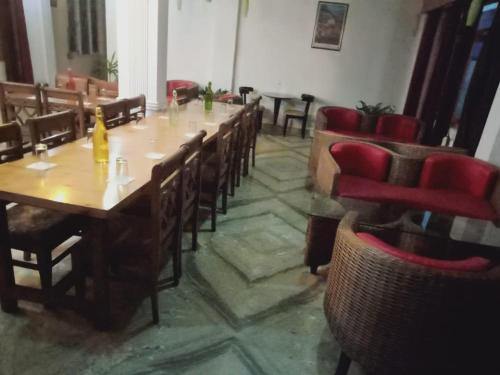 een eetkamer met houten tafels en rode stoelen bij Hotel Sunshine Dharamshala in Dharamshala