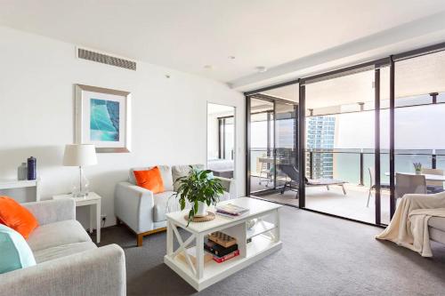 a living room with a couch and a table at Sealuxe - Central Surfers Paradise -- Ocean View Deluxe Residences in Gold Coast