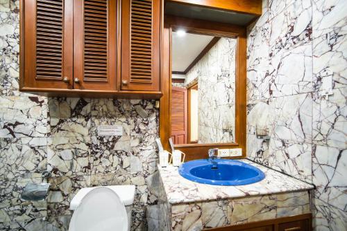 a bathroom with a blue sink and a stone wall at ZJ HOUSE in Patong Beach