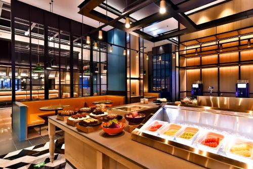 a buffet line in a restaurant with food at Four Points by Sheraton Taipei Bali in Bali