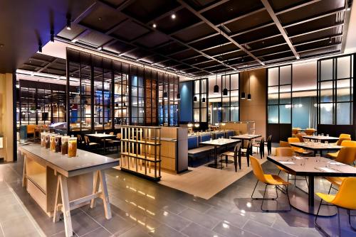 a restaurant with tables and chairs in a room at Four Points by Sheraton Taipei Bali in Bali