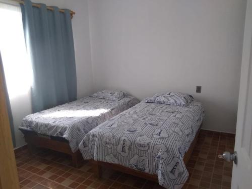 a small bedroom with a bed with a blanket on it at Hermosa casa Tequis en Tequisquiapan in Tequisquiapan