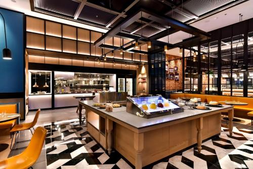 a restaurant with a counter with food on it at Four Points by Sheraton Taipei Bali in Bali