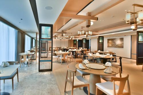 a dining room with tables and chairs and windows at Four Points by Sheraton Taipei Bali in Bali