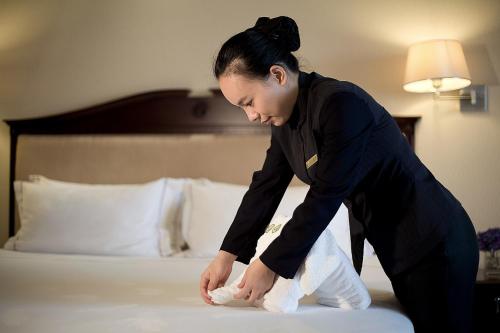 a woman standing on top of a bed at Guangzhou Phoenix City Hotel-Free Shuttle for Canton Fair 15th Oct to 5th Nov in Zengcheng