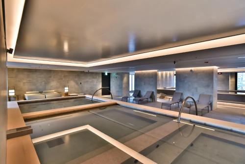 a large swimming pool in a building with chairs at Four Points by Sheraton Taipei Bali in Bali