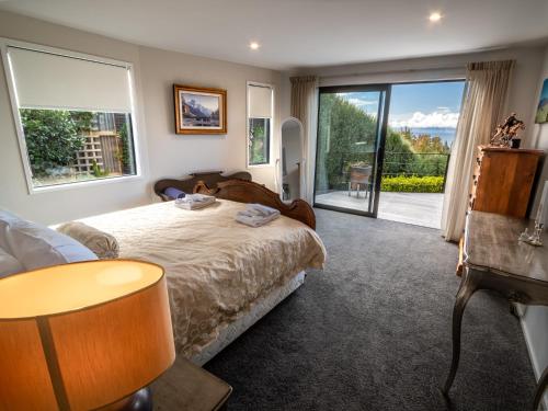 a bedroom with a bed and a sliding glass door at Number One Bach - Kaiteriteri Holiday Home in Kaiteriteri
