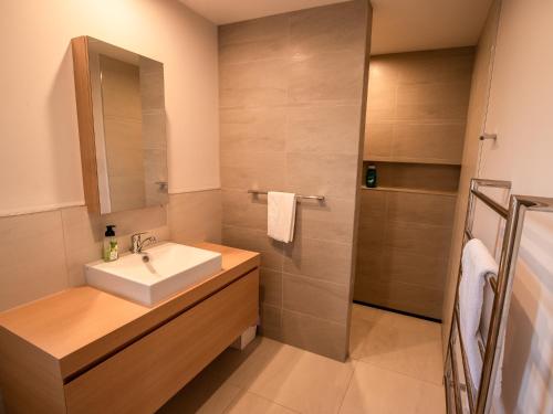 a bathroom with a sink and a shower at Number One Bach - Kaiteriteri Holiday Home in Kaiteriteri