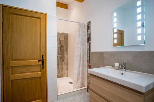 a bathroom with a sink and a shower and a door at Domaine L'Helion in Taradeau