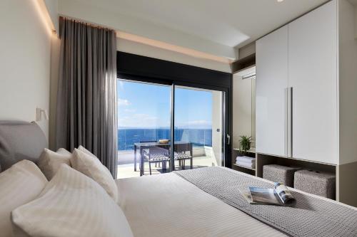 Schlafzimmer mit einem Bett und einem großen Fenster mit Aussicht in der Unterkunft Pachnes Luxury Apartments - Heated Pool, Sea View in Kounoupidiana