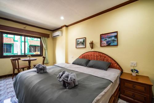 1 dormitorio con 1 cama con 2 toallas en ZJ HOUSE en Patong