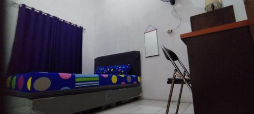um quarto com uma cama e uma cortina azul em FAI Bogor Backpacker by SPAZIE em Bogor