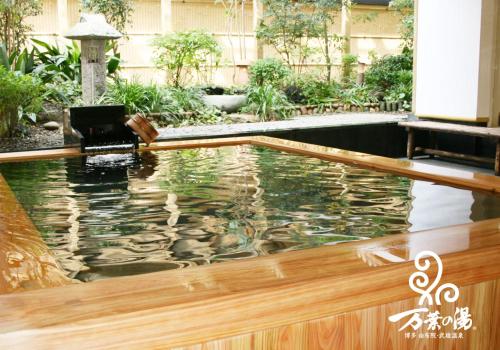 Hakataにある博多　由布院・武雄温泉　万葉の湯の木製デッキ付きの建物内の水プール