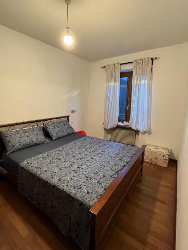 科爾蒙斯的住宿－Cormòns，一间卧室设有一张大床和一个窗户。