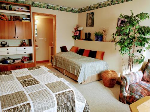 - une chambre avec deux lits et une plante dans l'établissement PineWood Guesthouse, à Peachland