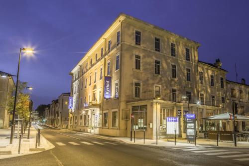 a large building on a city street at night at HOTEL KYRIAD ORANGE Centre Ville - A7-A9 - 3 Etoiles - HOTEL DES PRINCES - Provence Alpes Côte d'Azur - France in Orange