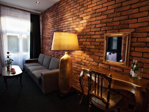 a living room with a couch and a brick wall at Hotel Betmanowska Main Square Residence Adults Only in Kraków