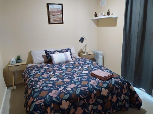 a bedroom with a bed with a blue comforter at 2BR house in West Lamington in Kalgoorlie